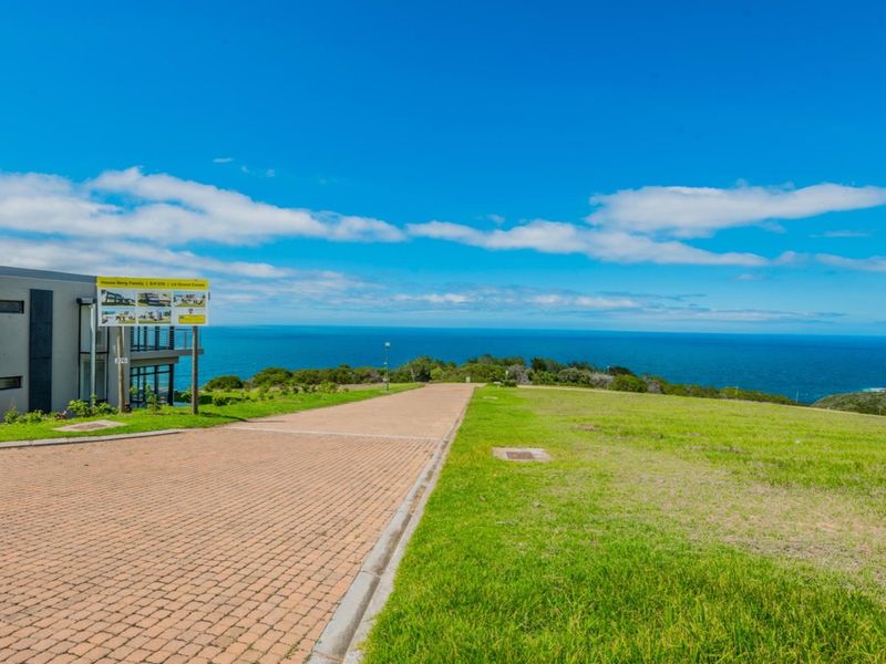 A vacant residential plot featuring a paved driveway and expansive, unobstructed ocean views.