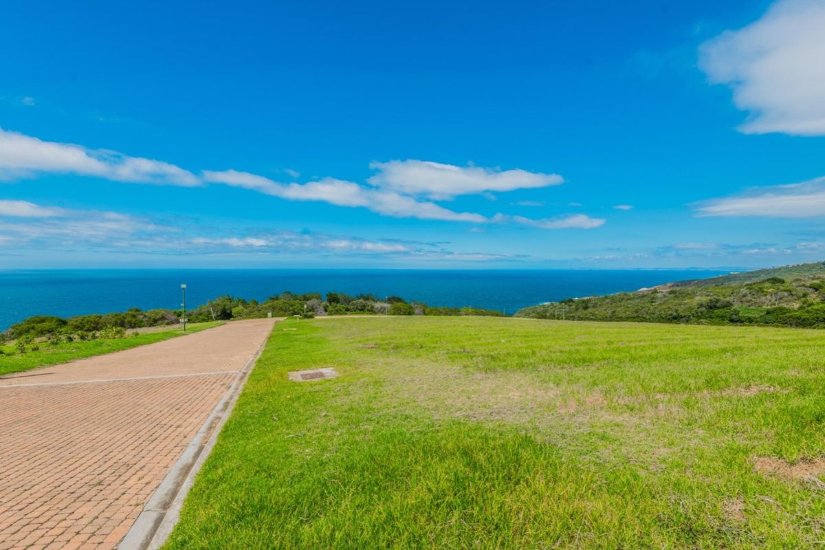 A vacant residential plot featuring a paved driveway and expansive, unobstructed ocean views.