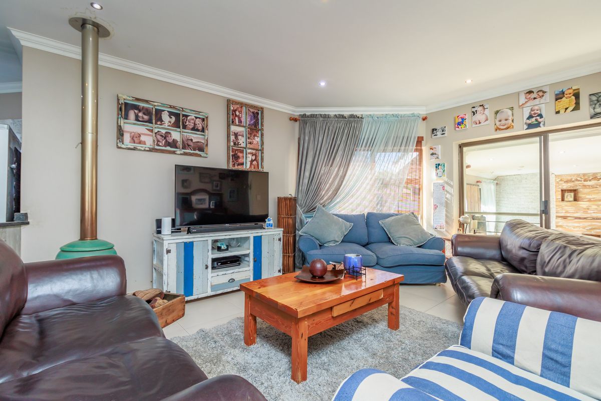 A comfortable living room featuring a freestanding fireplace, tiled flooring, and sliding glass doors that provide access to an adjoining patio area.