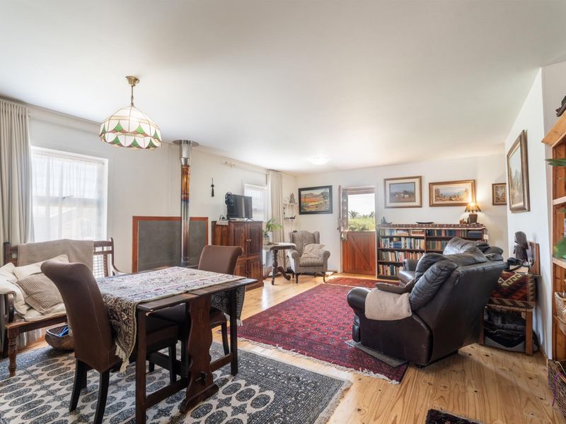 Spacious living area featuring timber flooring, a wood-burning stove, and a stable-style entrance door, offering a warm and inviting atmosphere.