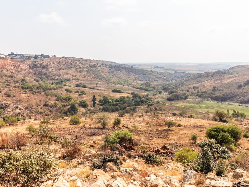 A wide-angle view of the natural landscape, showcasing the rolling hills and vegetation of the vacant residential land.