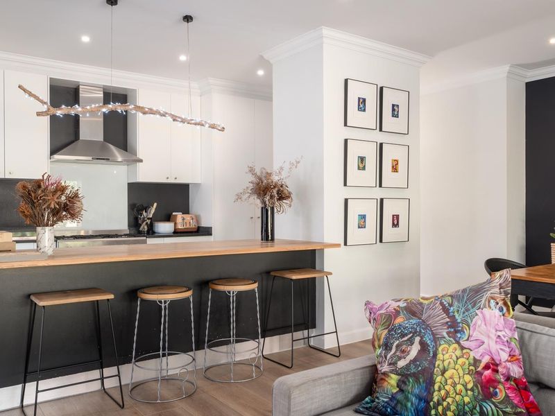 Modern open-plan living area featuring a sleek kitchen with breakfast bar, contemporary cabinetry, and high-quality finishes throughout.