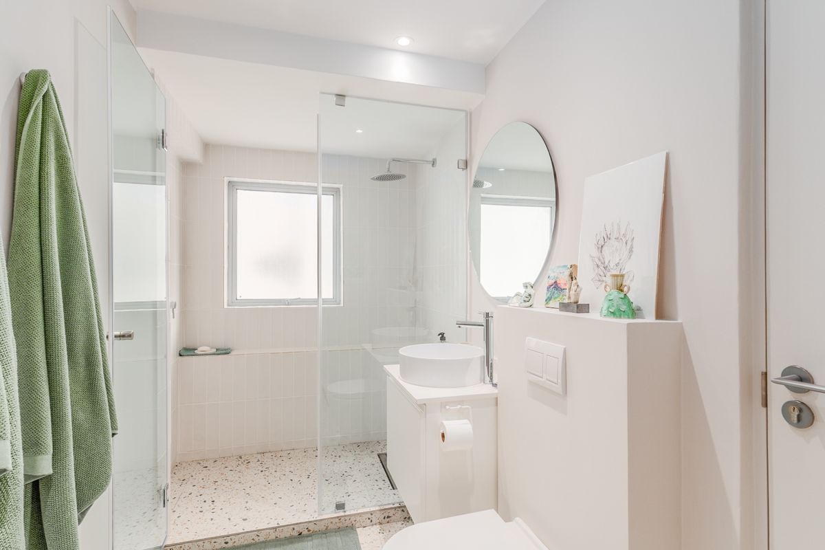 Modern bathroom featuring a walk-in glass shower, terrazzo-style flooring, a contemporary vessel sink vanity, and a wall-mounted toilet.