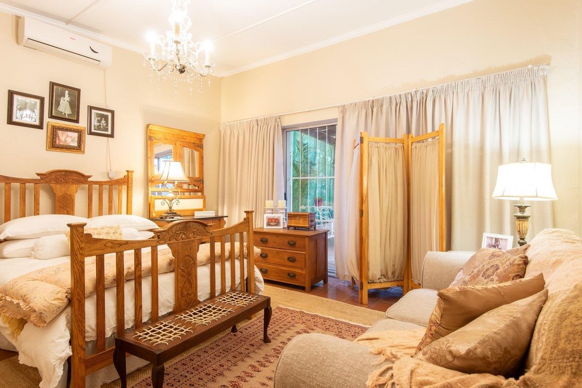 Spacious bedroom featuring tiled flooring, a wall-mounted air conditioning unit, and sliding glass doors providing access to an outdoor area.