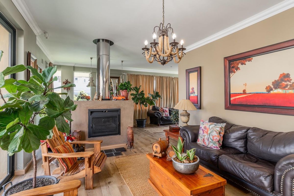Spacious living area featuring a central built-in fireplace with a stainless steel flue, crown molding, and large sliding doors leading to the outdoors.