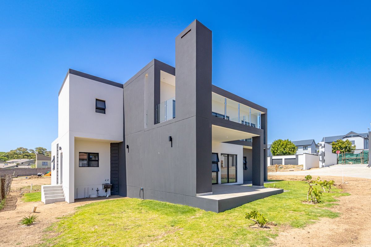 Modern double-story residence featuring a contemporary architectural design, covered patio, glass balcony railings, and a spacious rear garden area.