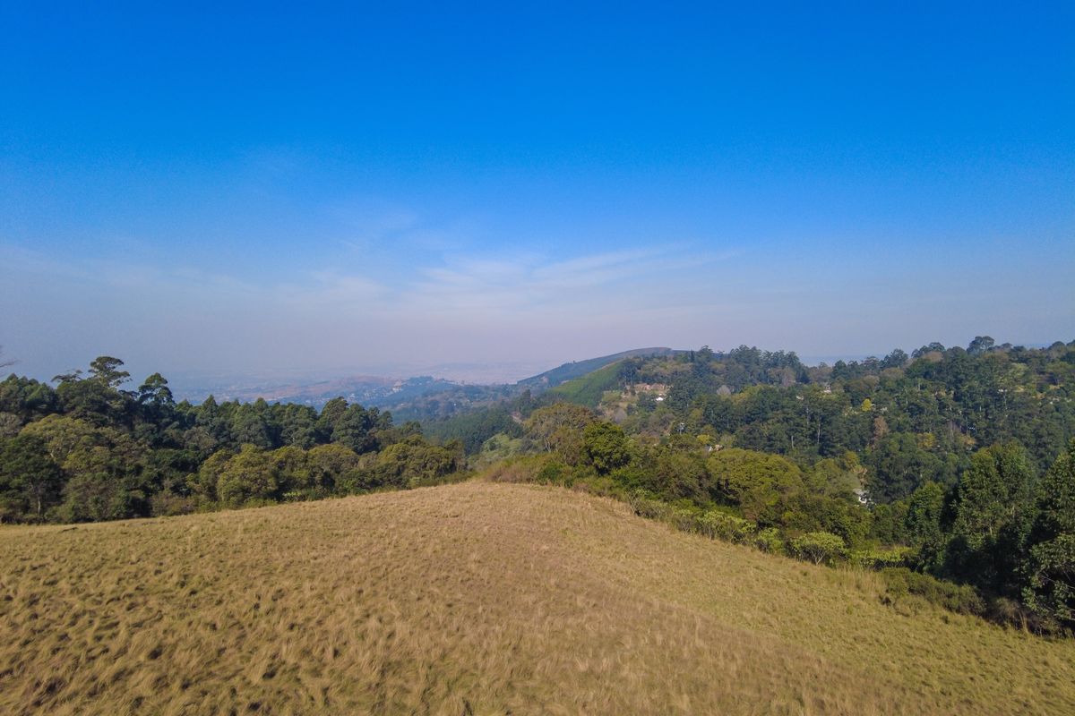 An elevated view of the vacant residential land, showcasing the natural landscape, surrounding greenery, and distant horizon.