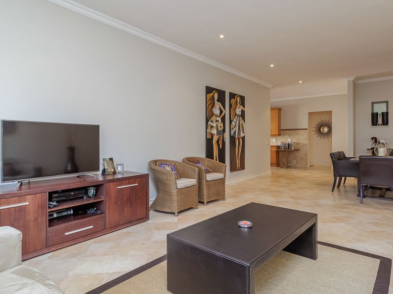 Spacious open-plan living and dining area featuring tiled flooring, recessed downlighting, and seamless flow into the kitchen space.