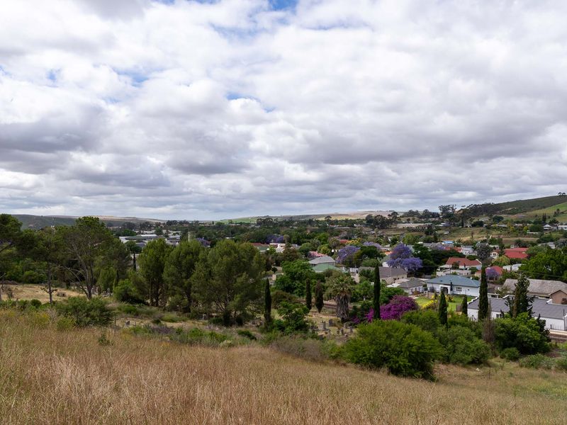 An elevated view overlooking a residential neighborhood and surrounding landscape, showcasing the natural terrain and local environment.