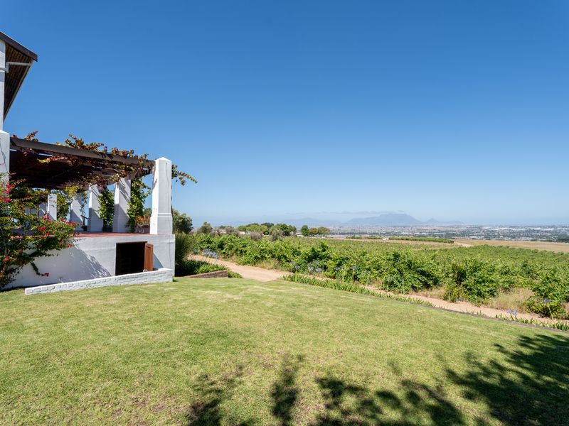 A scenic view of the vineyard and surrounding landscape from the covered patio area of the farmhouse.