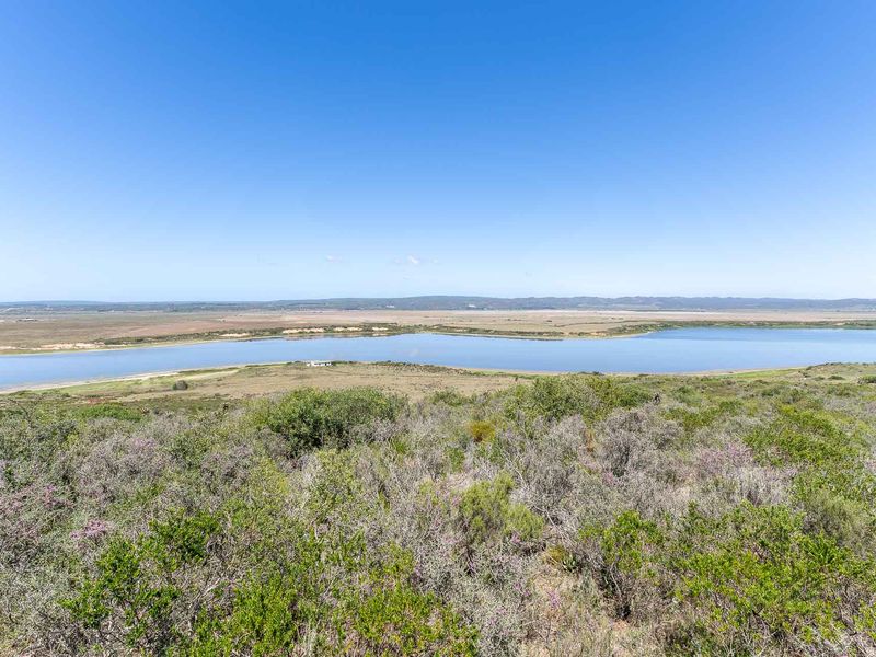 Expansive panoramic landscape view overlooking a natural lake and surrounding rural terrain.