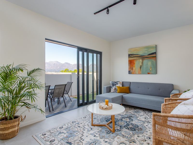 Bright living room featuring large sliding glass doors that open onto a private patio with scenic mountain views.