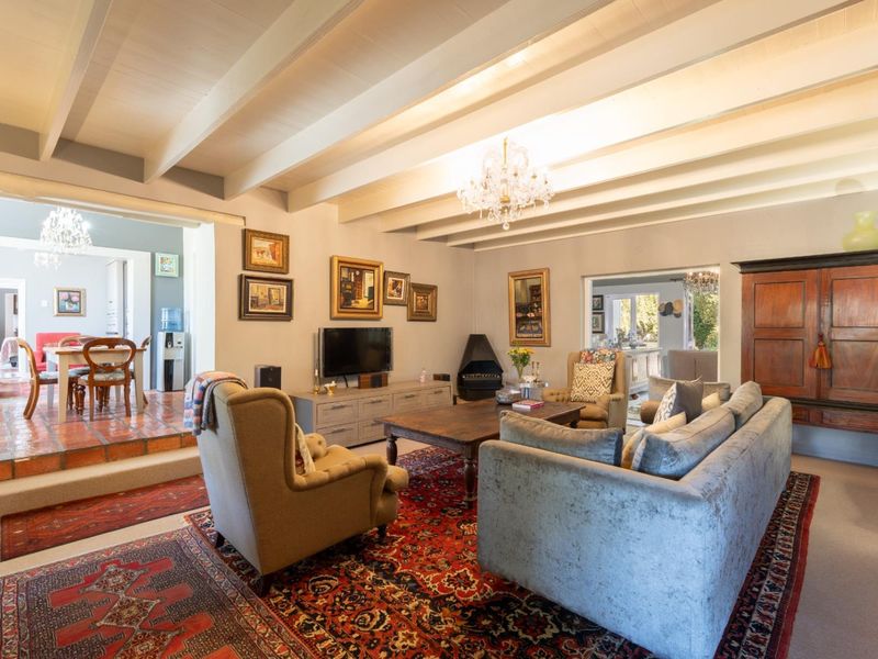 Spacious living room featuring exposed beam ceilings, a fireplace, and a split-level layout connecting to the dining area.