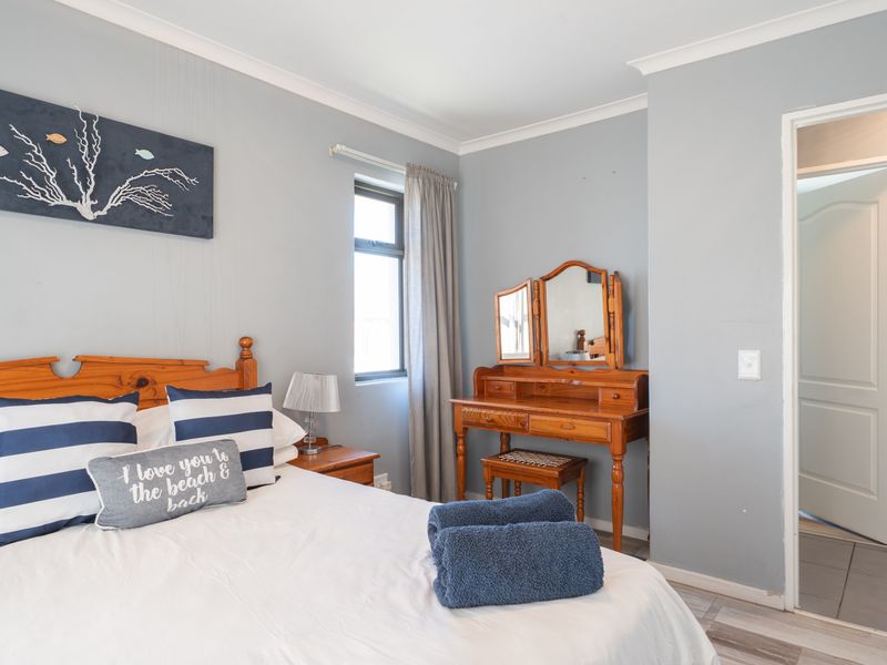 A well-maintained bedroom featuring neutral wall tones, coving, and an adjoining bathroom with tiled flooring.