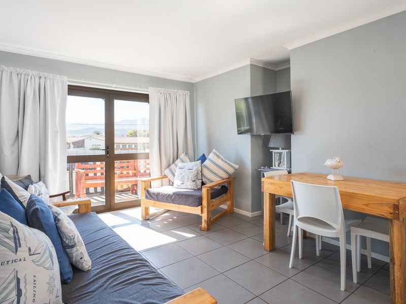 Open-plan living and dining area featuring tiled flooring and a sliding glass door providing access to an outdoor balcony.