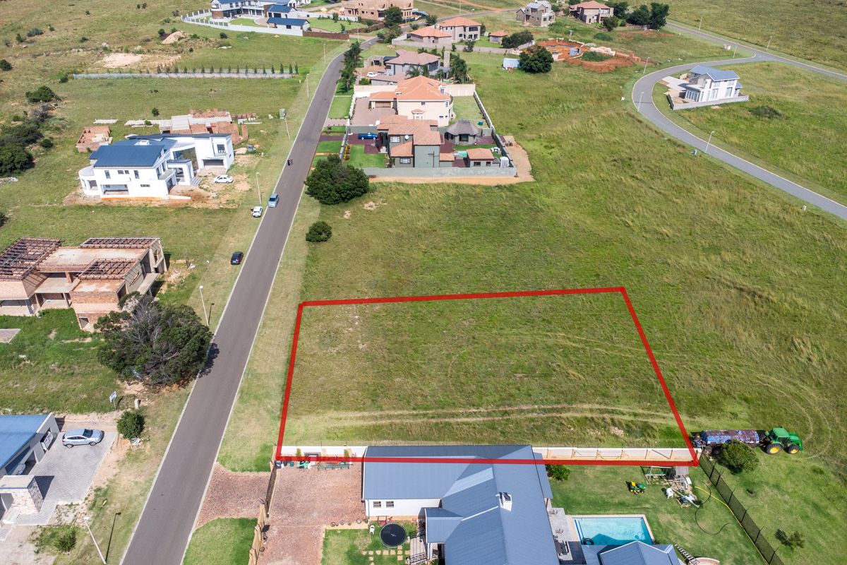 Aerial view of a vacant residential plot in a developed estate, featuring clear boundary lines and surrounding neighborhood infrastructure.