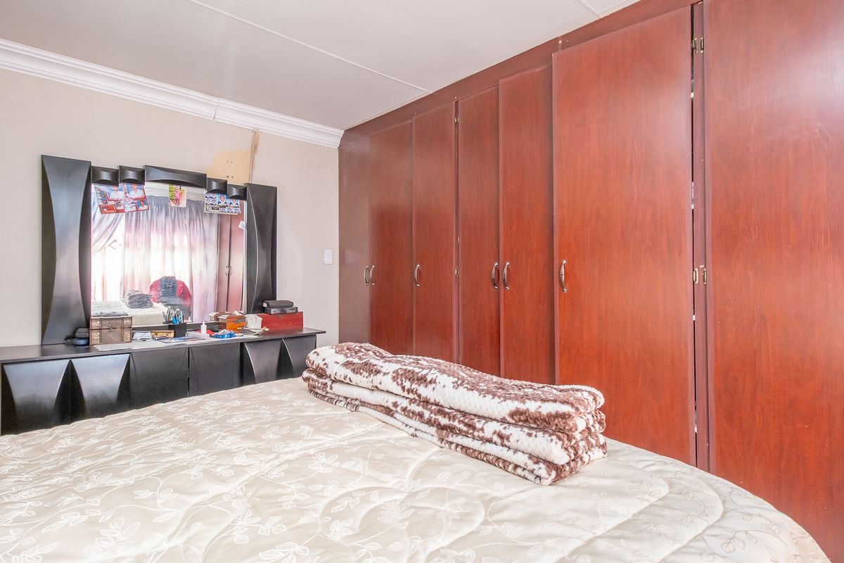 A bedroom featuring extensive floor-to-ceiling built-in wooden cabinetry providing ample storage space.