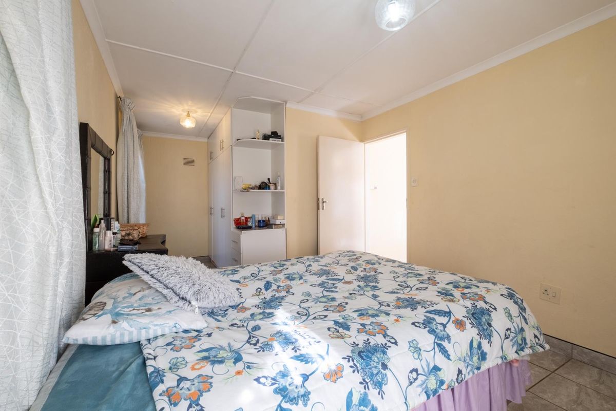 A bedroom featuring built-in cupboards with open shelving and tiled flooring.