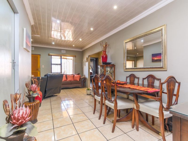 Open-plan living and dining area featuring tiled flooring, recessed ceiling lighting, and a glossy panelled ceiling finish.