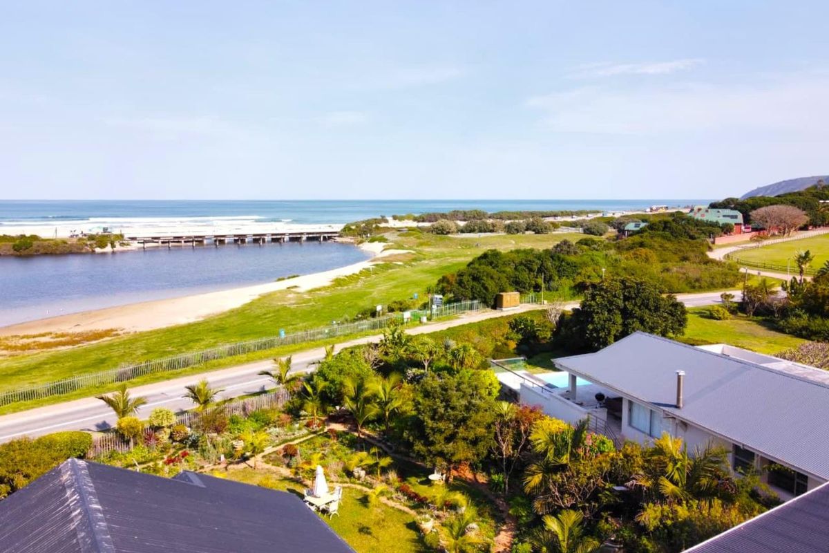 Aerial view of the property showcasing the landscaped garden, swimming pool, and proximity to the coastal lagoon and beach.