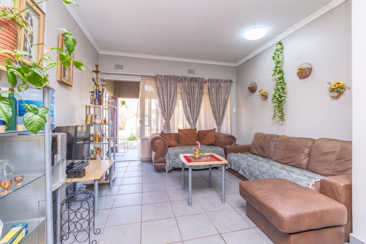 A living room featuring tiled flooring and a sliding door providing access to an outdoor area.