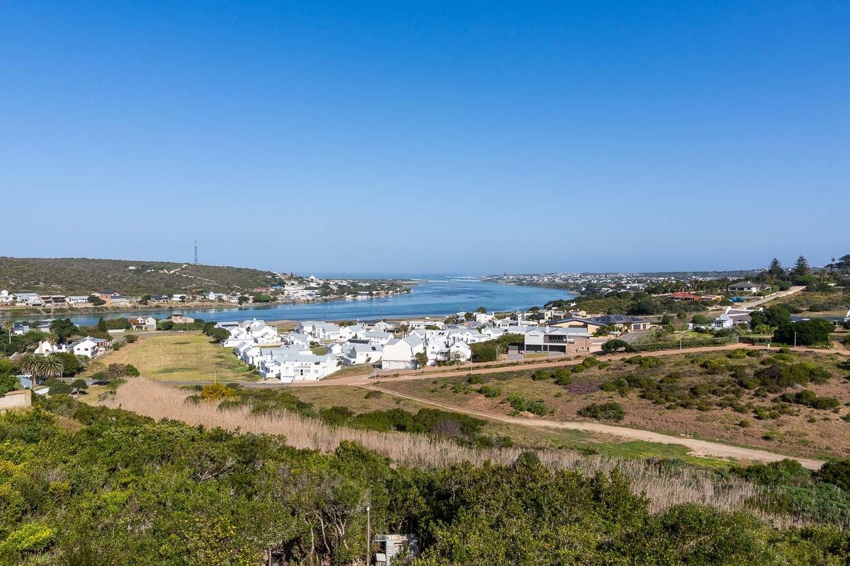 An elevated aerial view showcasing the surrounding coastal landscape, estuary, and residential neighborhood.
