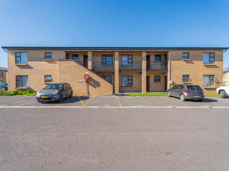 Front elevation of a two-story face brick apartment complex featuring designated parking bays and balcony access.