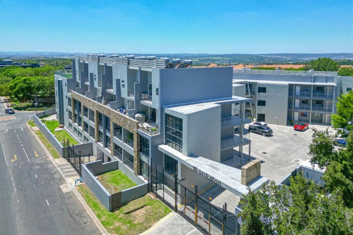 Aerial view of the 10 on Eaton apartment complex, showcasing the modern building architecture, parking facilities, and secure gated entrance.