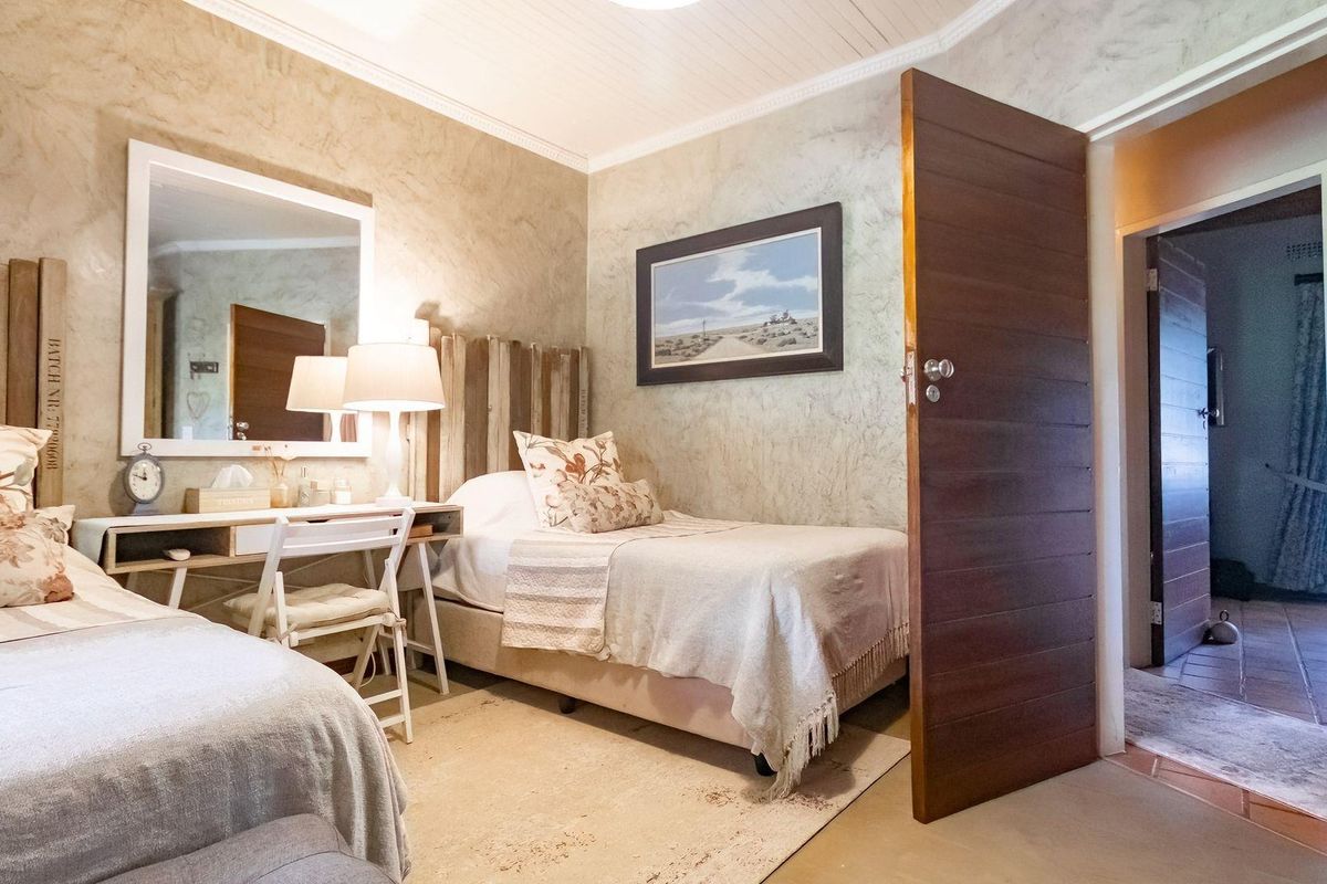 A cozy bedroom featuring textured wall finishes, a wooden door, and a built-in vanity area with a mirror.