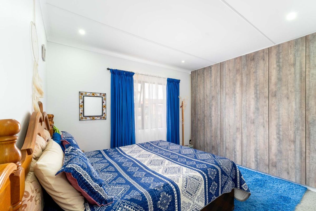 A bedroom featuring built-in floor-to-ceiling wood-look cabinetry and recessed downlighting.