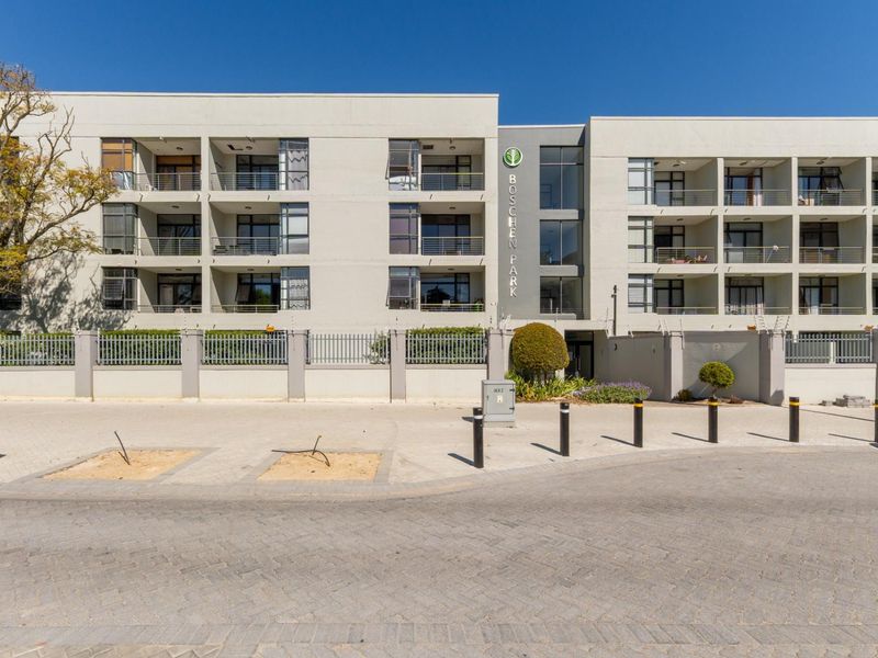 Front elevation of Boschen Park apartment complex featuring modern facade, private balconies, and secure perimeter fencing.