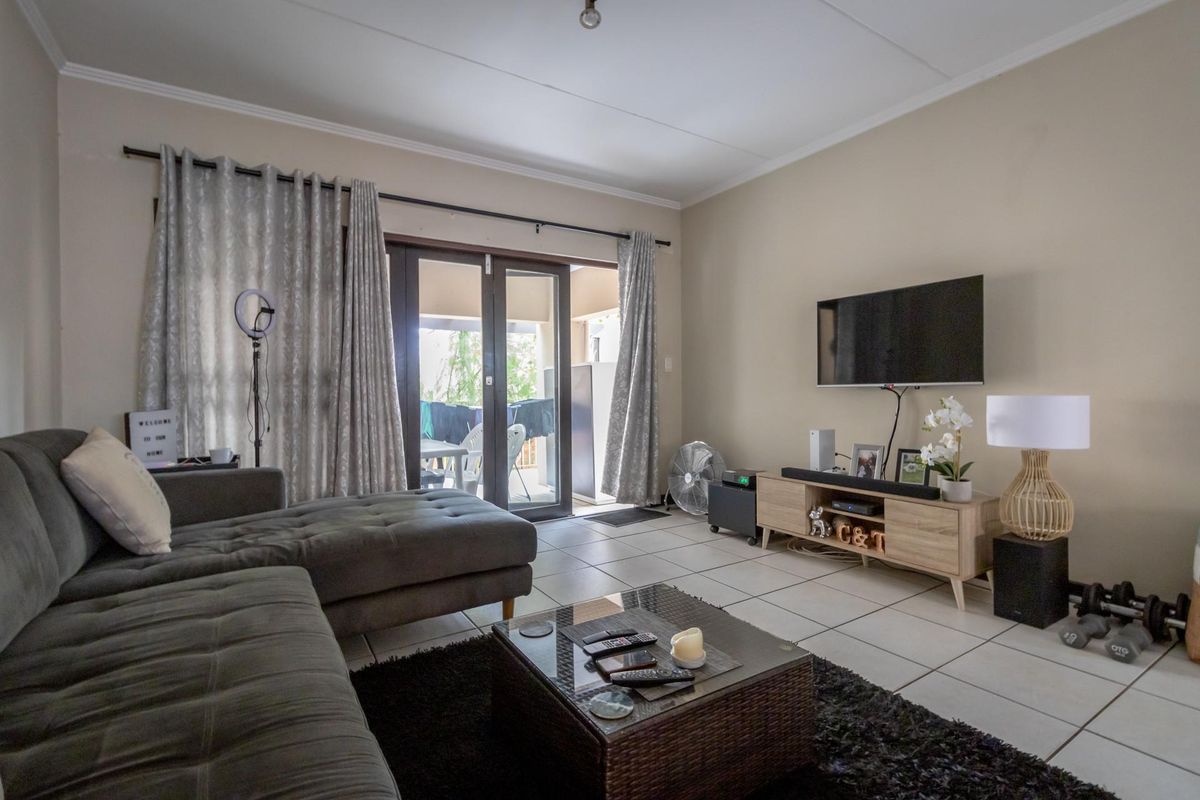 A comfortable living room featuring tiled flooring and sliding glass doors that provide direct access to an outdoor patio area.