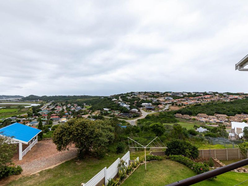 Elevated view overlooking the surrounding residential estate, green landscape, and distant coastal area from an upper-level vantage point.