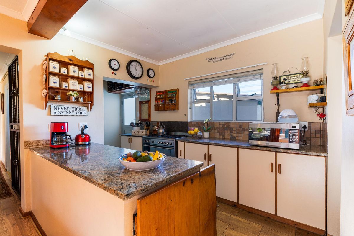 A functional kitchen featuring granite countertops, a built-in gas stove, and ample cabinetry, offering a practical layout for daily meal preparation.