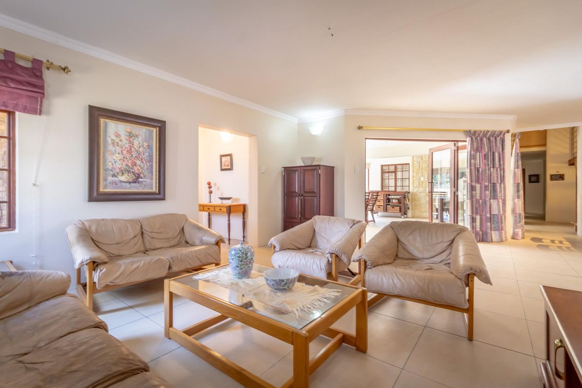 Spacious living room featuring neutral ceramic floor tiles, coved ceilings, and large sliding glass doors providing access to the outdoor patio area.