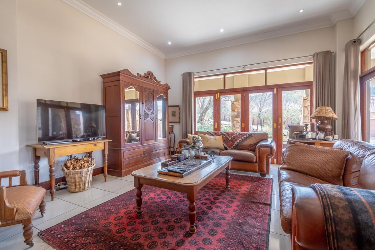 Spacious living room featuring large wooden framed glass doors that open to the patio, tiled flooring, and recessed ceiling lighting.