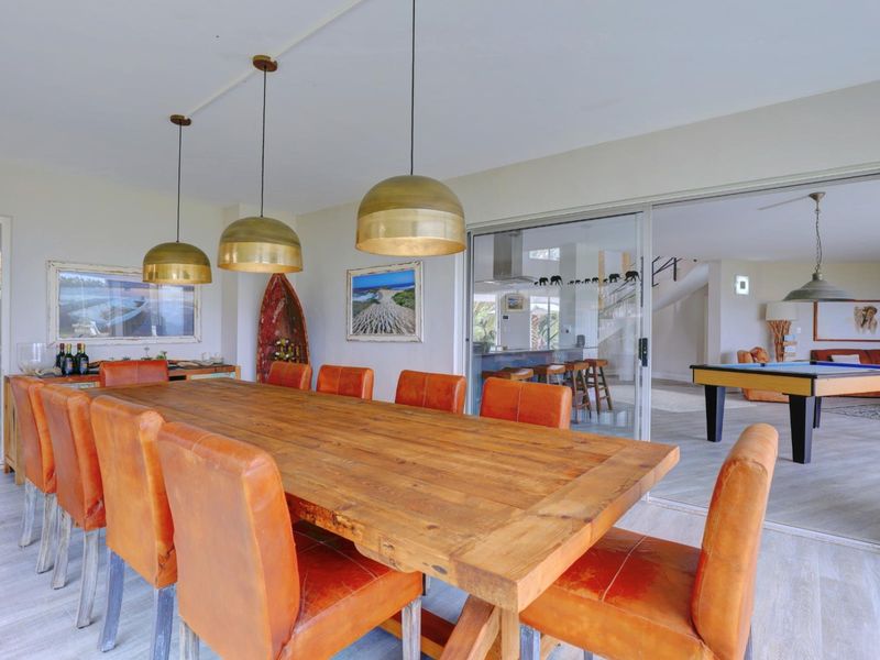 Spacious dining area featuring modern laminate flooring and large sliding glass doors that provide a seamless transition to the adjacent living space.