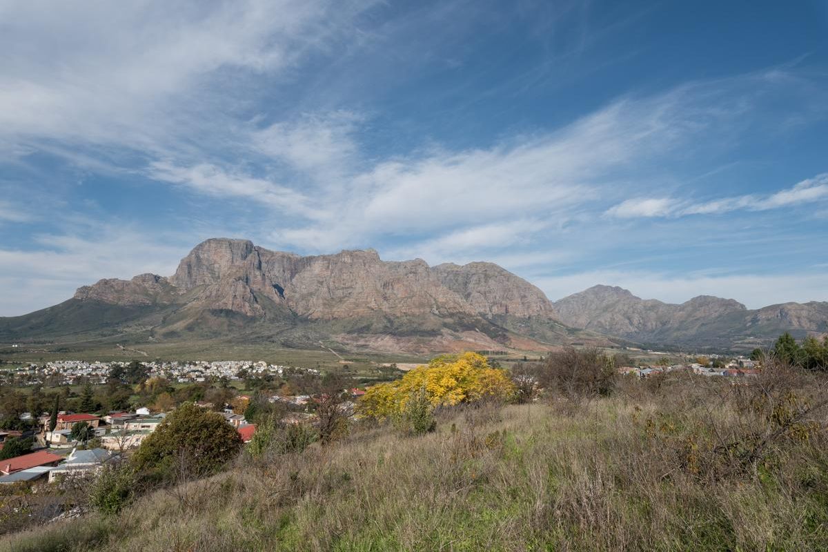 A scenic landscape view overlooking a residential area with a prominent mountain range in the background.