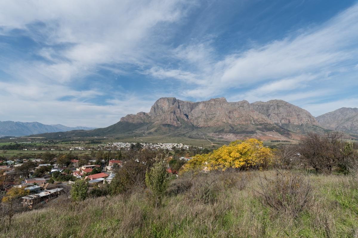 A scenic landscape view overlooking a residential area with a prominent mountain range in the background.