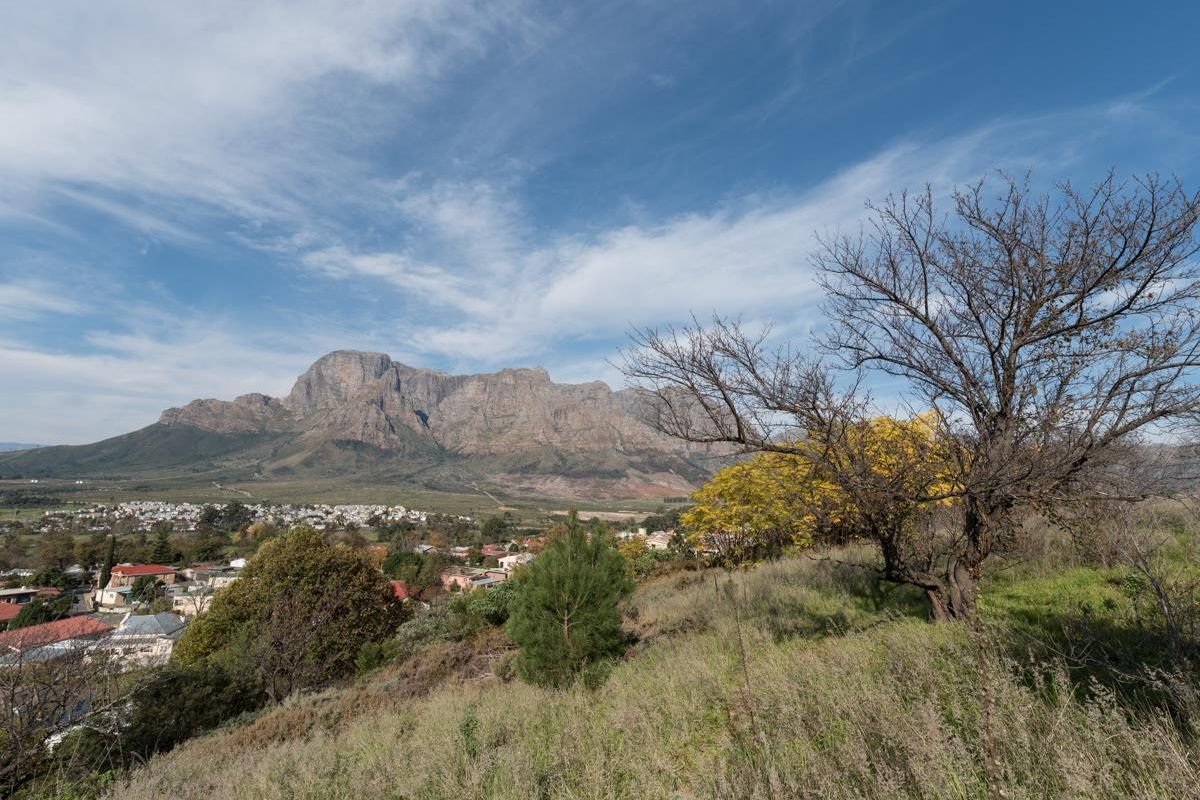 A scenic landscape view overlooking a residential area with a prominent mountain range in the background.
