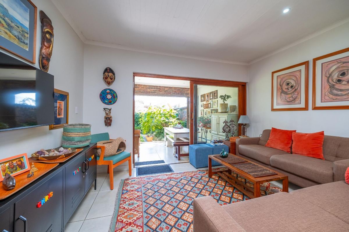 A comfortable living room featuring tiled flooring and a large sliding glass door that provides direct access to an outdoor patio area.