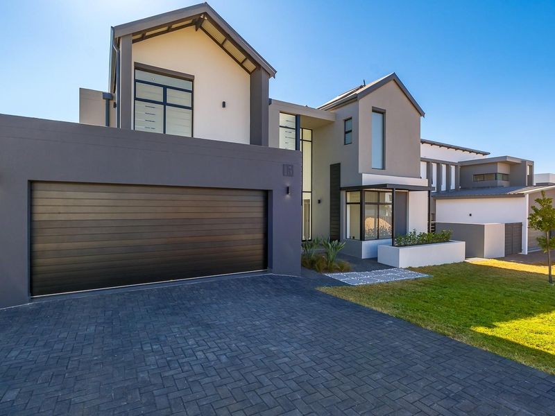 Modern double-story residential home featuring a contemporary facade, paved driveway, and integrated double garage with well-maintained front garden.