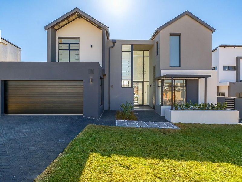Modern double-story residential home featuring a contemporary facade, integrated double garage, and a landscaped front garden with paved driveway.