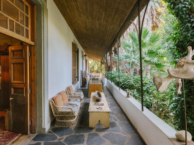 A covered veranda featuring stone flooring, timber ceiling, and direct access to the garden, providing a sheltered outdoor living space.