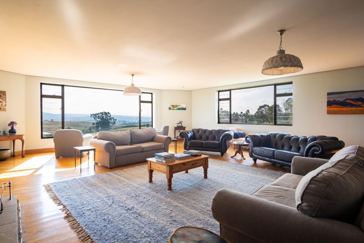 Spacious living room featuring large windows with panoramic views, hardwood flooring, and recessed lighting.