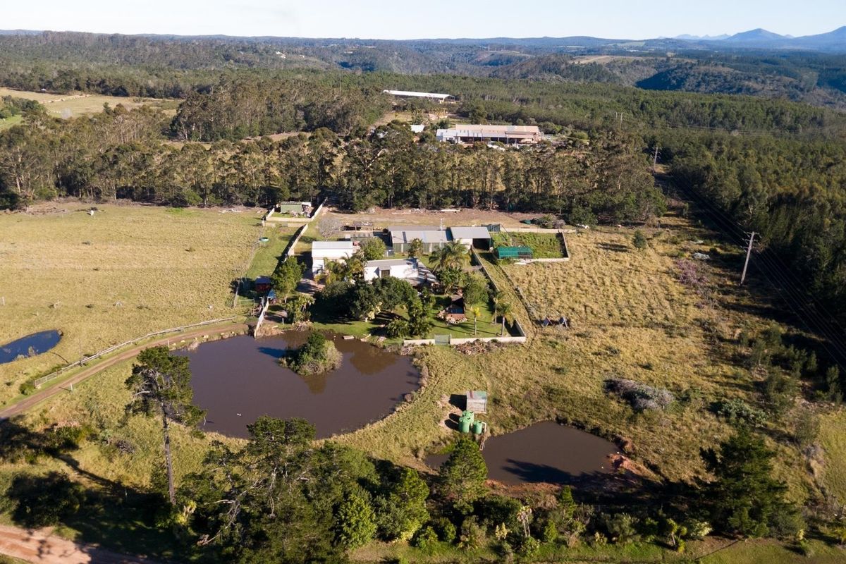 Aerial view of a rural farm property featuring multiple dams, fenced paddocks, and a central residential complex surrounded by natural landscape.