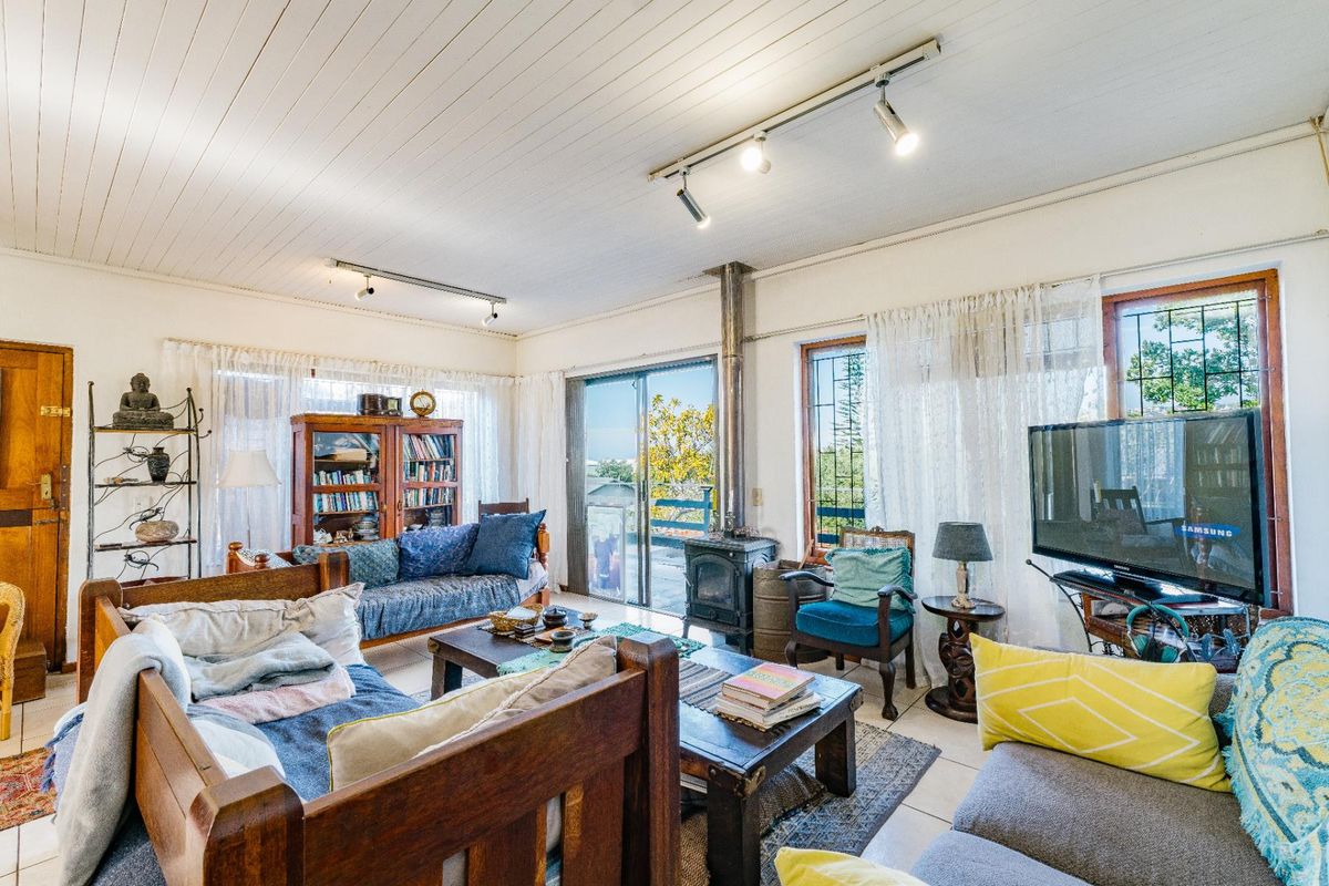 Spacious living room featuring a wood-burning stove, tiled flooring, timber-paneled ceiling, and sliding glass doors leading to an outdoor area.