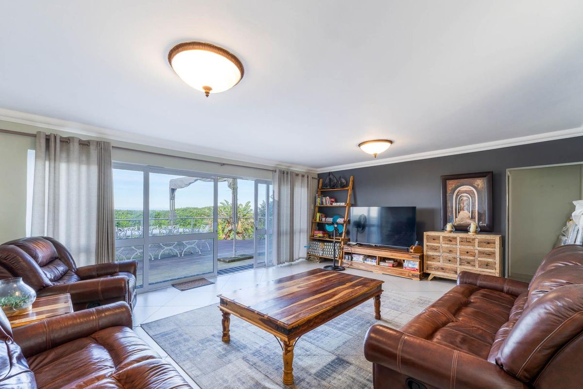 Spacious living room featuring large sliding glass doors that open onto an outdoor deck, providing natural light and scenic views.