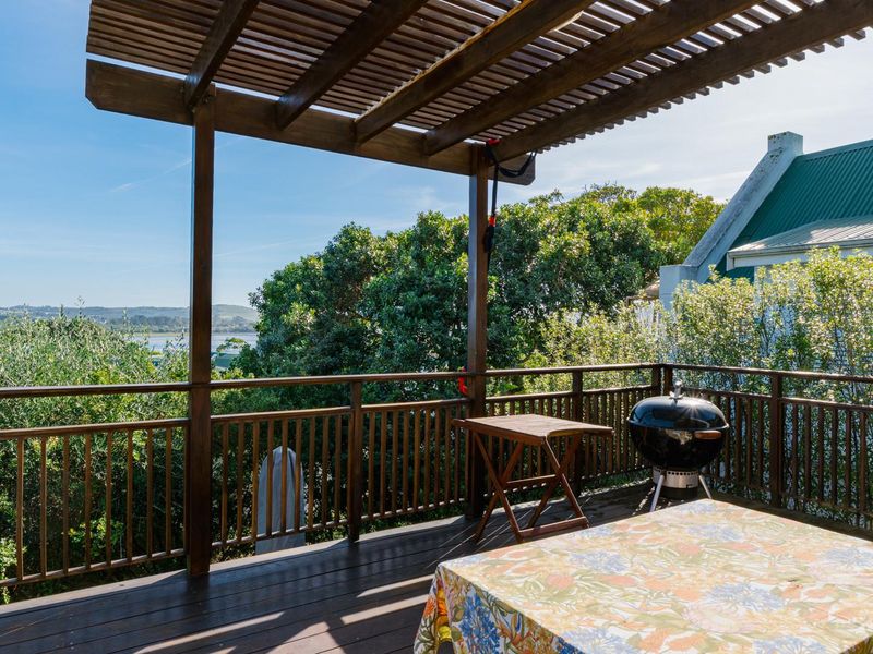 A spacious elevated wooden deck featuring a pergola and balustrade, offering scenic outdoor views and a perfect setting for relaxation.