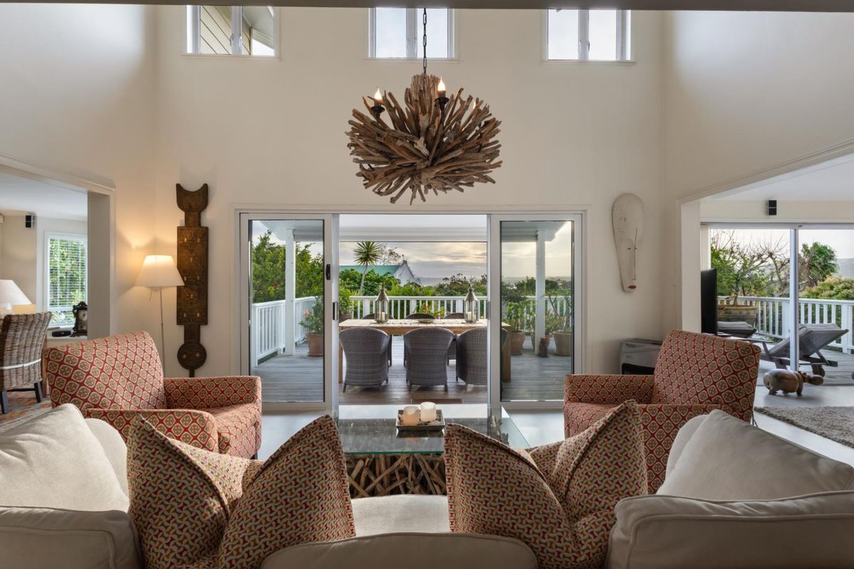 Spacious living area with high ceilings, large sliding glass doors, and seamless flow to an outdoor patio with scenic views.